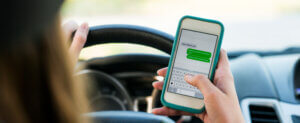 A woman driving and texting on her cell phone