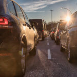 Cars sitting in rush hour traffic, one of them with an expired registration.